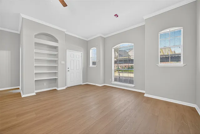 wooden floor fireplace and windows in an empty room