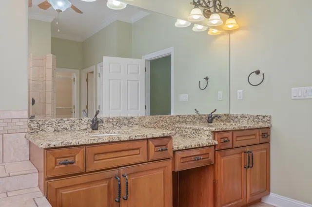 a bathroom with a granite countertop double vanity sink and a mirror
