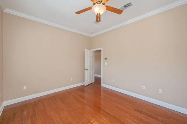 a view of an empty room with wooden floor