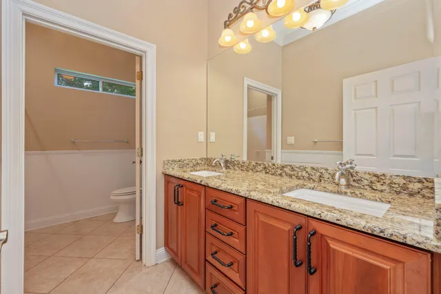 a bathroom with a granite countertop sink toilet and a mirror