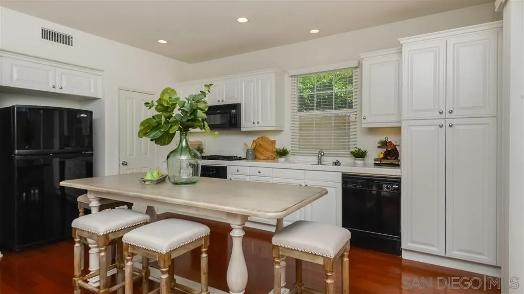 12 Night Bloom Irvine, CA 92602 - Photo 7 of 25 a kitchen with a table chairs refrigerator and microwave