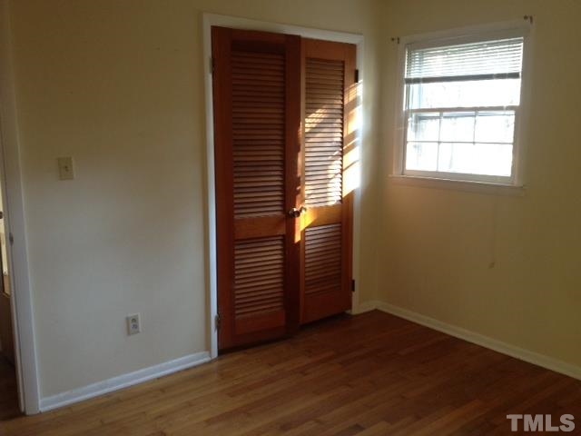 5001 Auburn Road Raleigh, NC 27609 - Photo 8 of 20 an empty room with wooden floor and windows