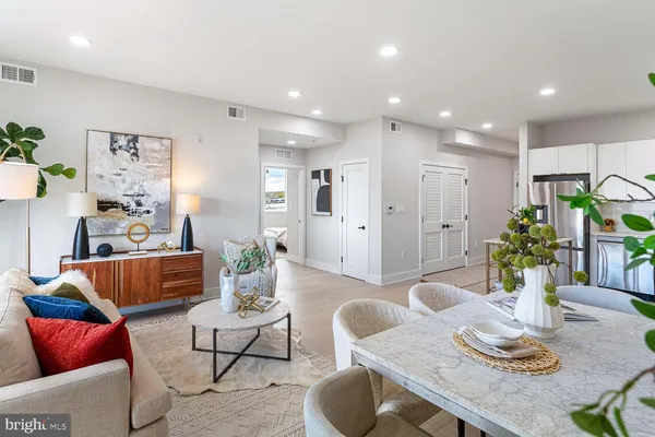 a living room with furniture a dining table and kitchen view