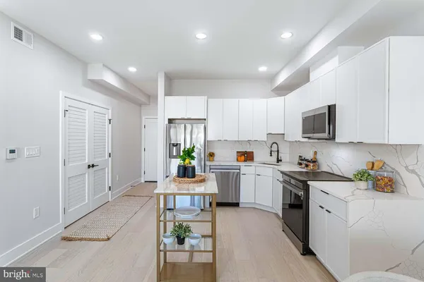 a kitchen with stainless steel appliances a refrigerator and a stove top oven