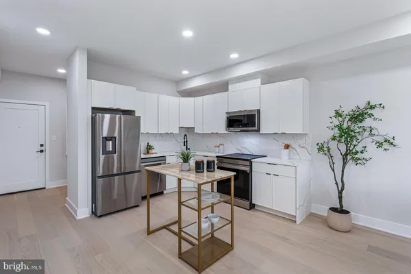 a kitchen with stainless steel appliances granite countertop a refrigerator and a stove top oven