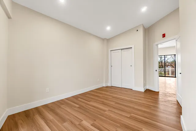 a view of empty room with wooden floor