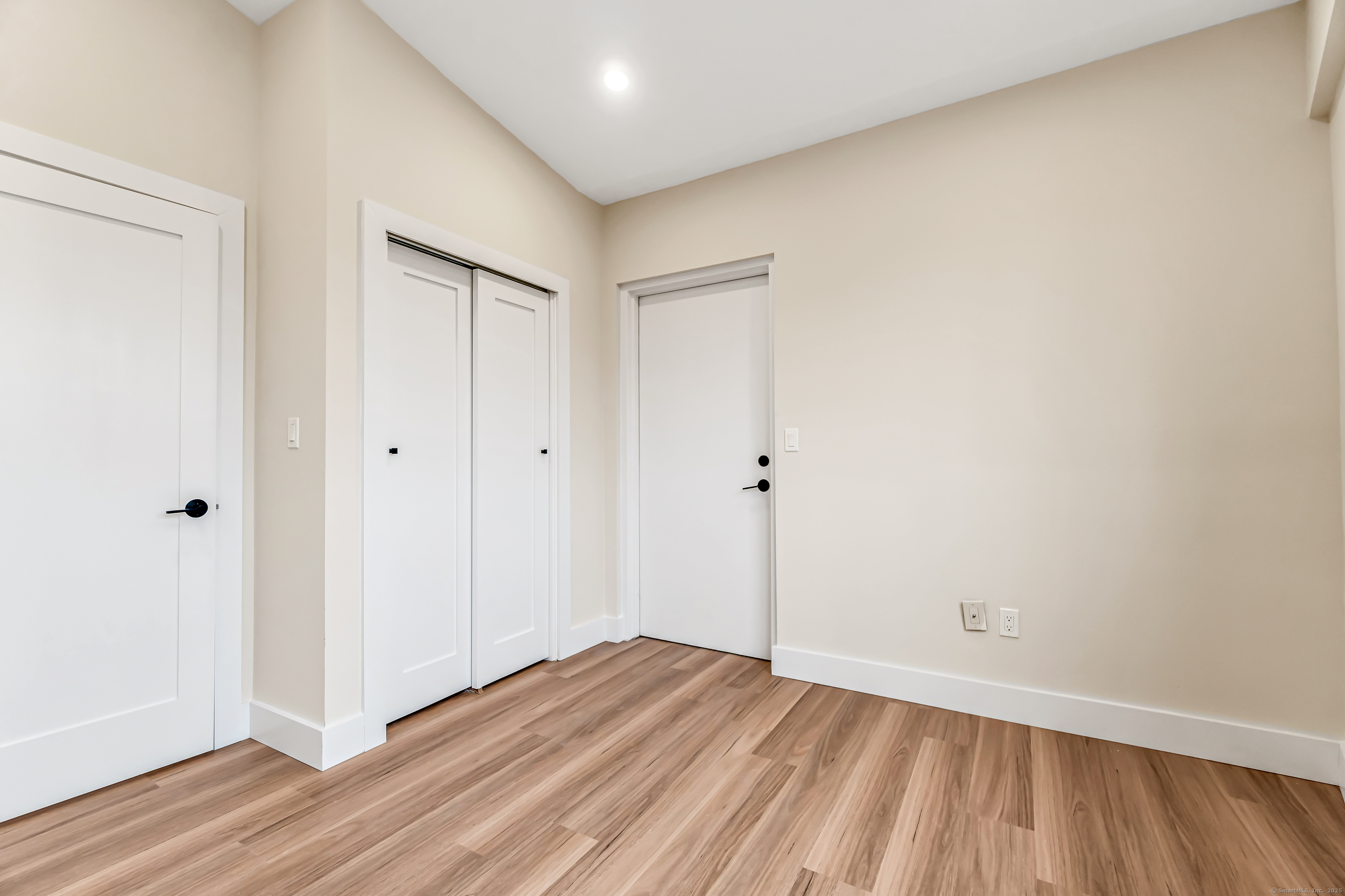 937 Post Road, Unit 3A Fairfield, CT 06824 - Photo 14 of 24 a view of an empty room with wooden floor