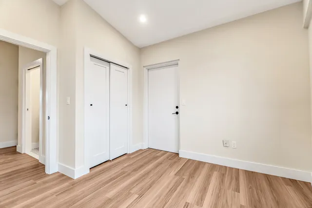 a view of an empty room with wooden floor