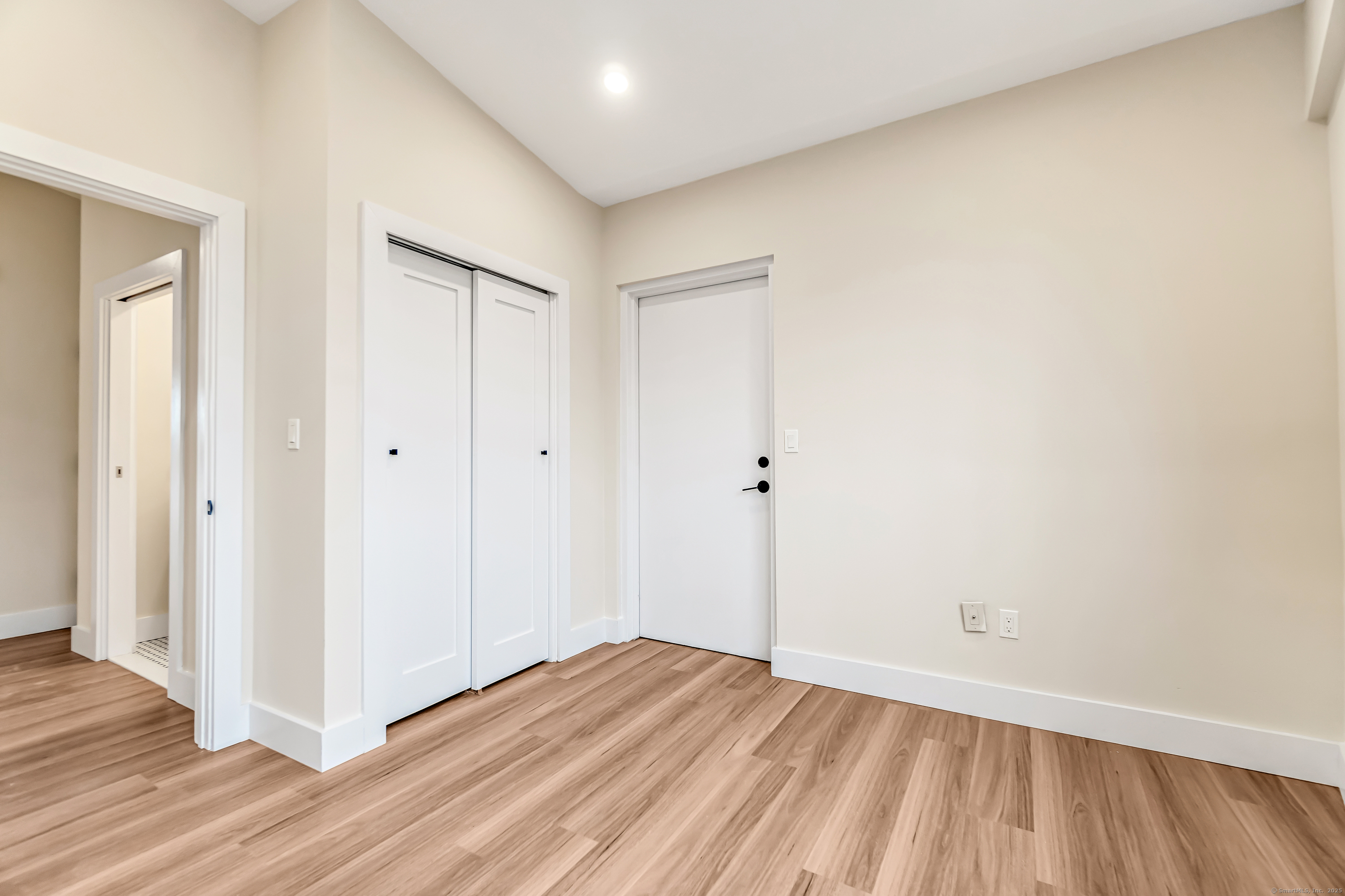 937 Post Road, Unit 3A Fairfield, CT 06824 - Photo 15 of 24 a view of an empty room with wooden floor