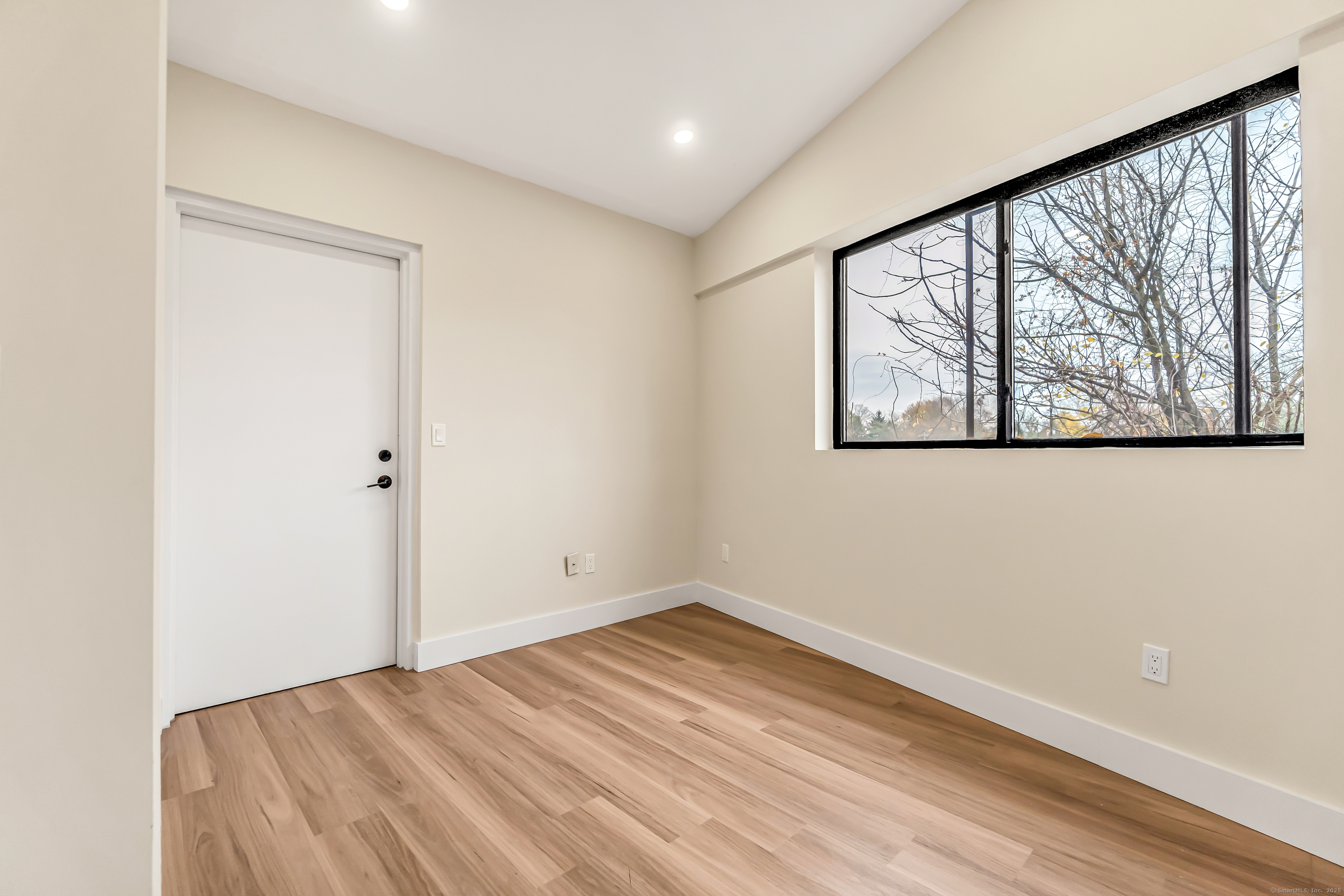 937 Post Road, Unit 3A Fairfield, CT 06824 - Photo 18 of 24 an empty room with wooden floor and windows