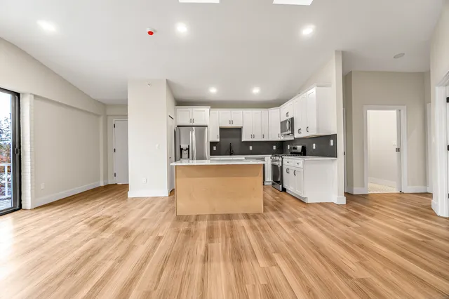 a view of kitchen with granite countertop cabinets and refrigerator