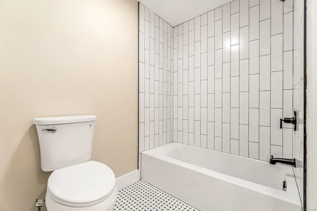 a white toilet sitting next to a bathtub