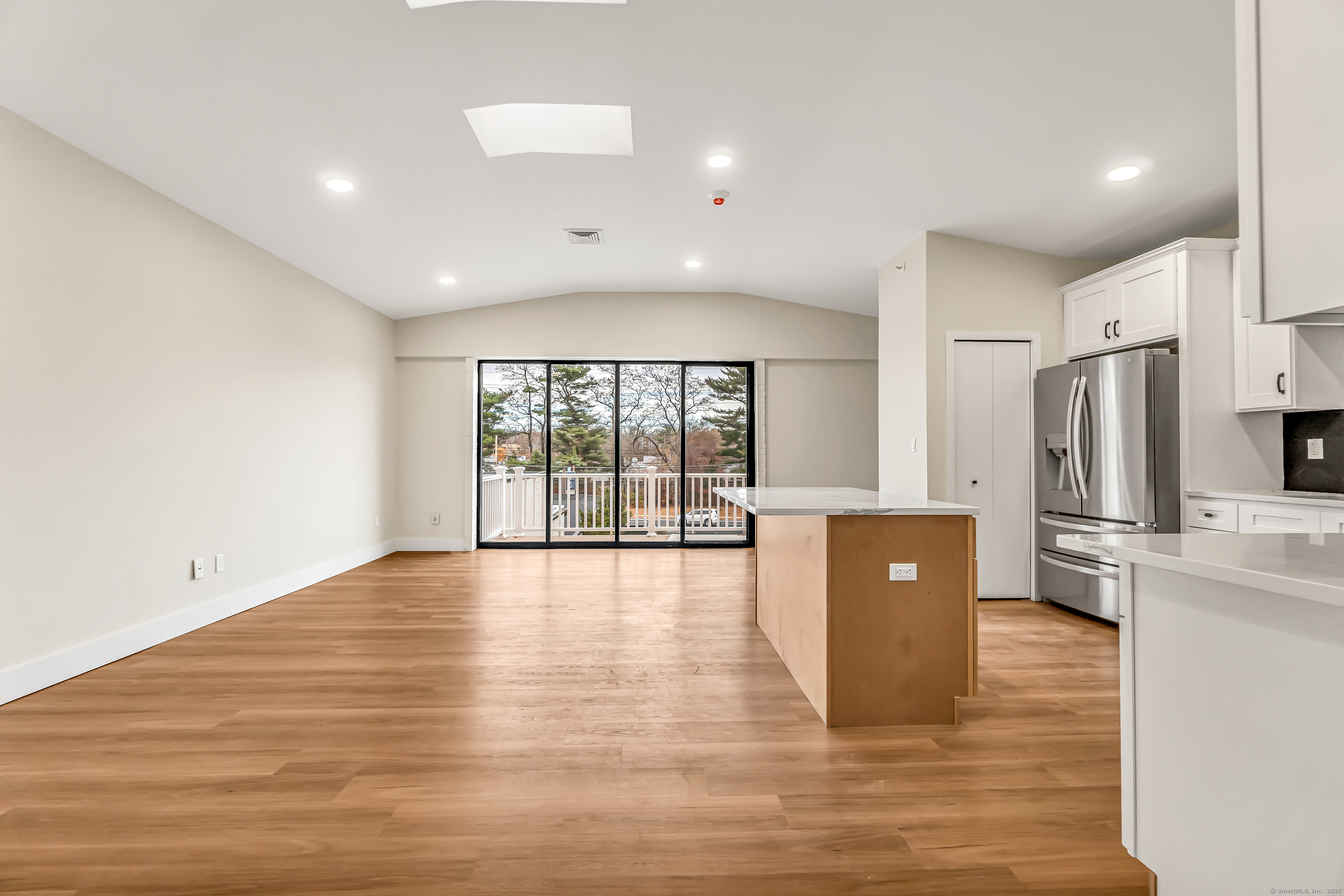 937 Post Road, Unit 3A Fairfield, CT 06824 - Photo 5 of 24 a view of kitchen with stainless steel appliances a refrigerator and wooden floor