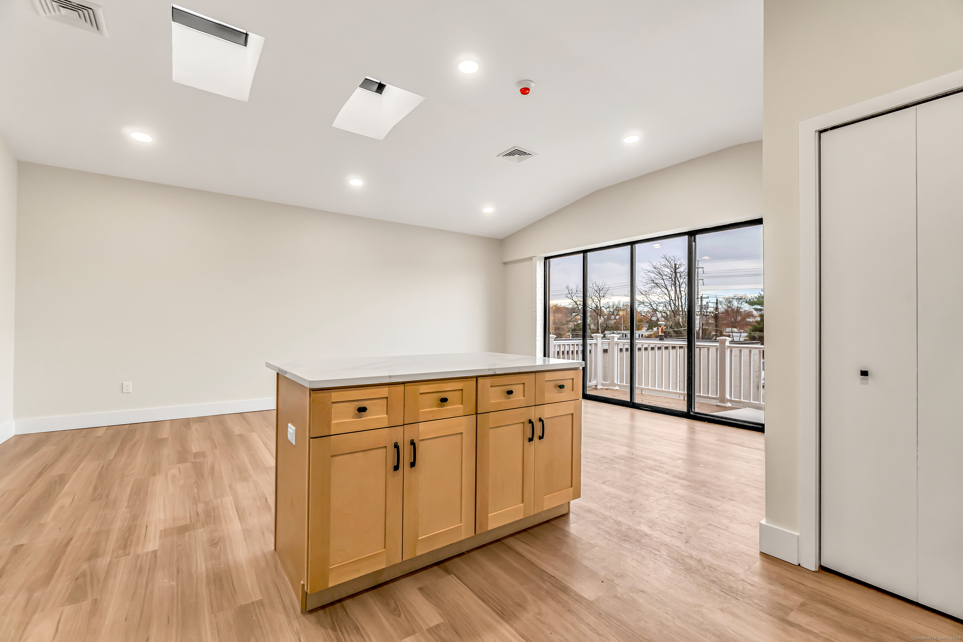 937 Post Road, Unit 3A Fairfield, CT 06824 - Photo 6 of 24 a view of an empty room with wooden floor and a window