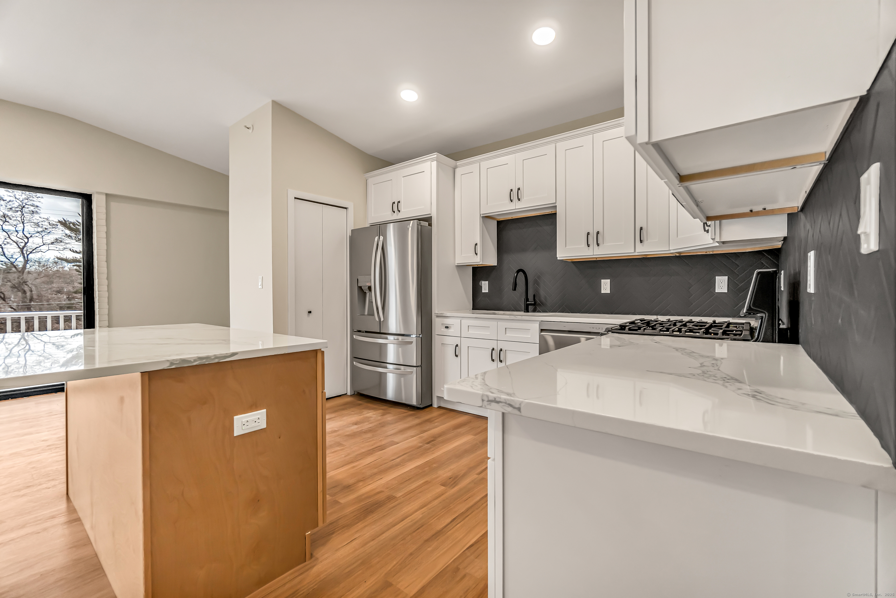 937 Post Road, Unit 3A Fairfield, CT 06824 - Photo 8 of 24 a kitchen with stainless steel appliances a refrigerator sink and cabinets