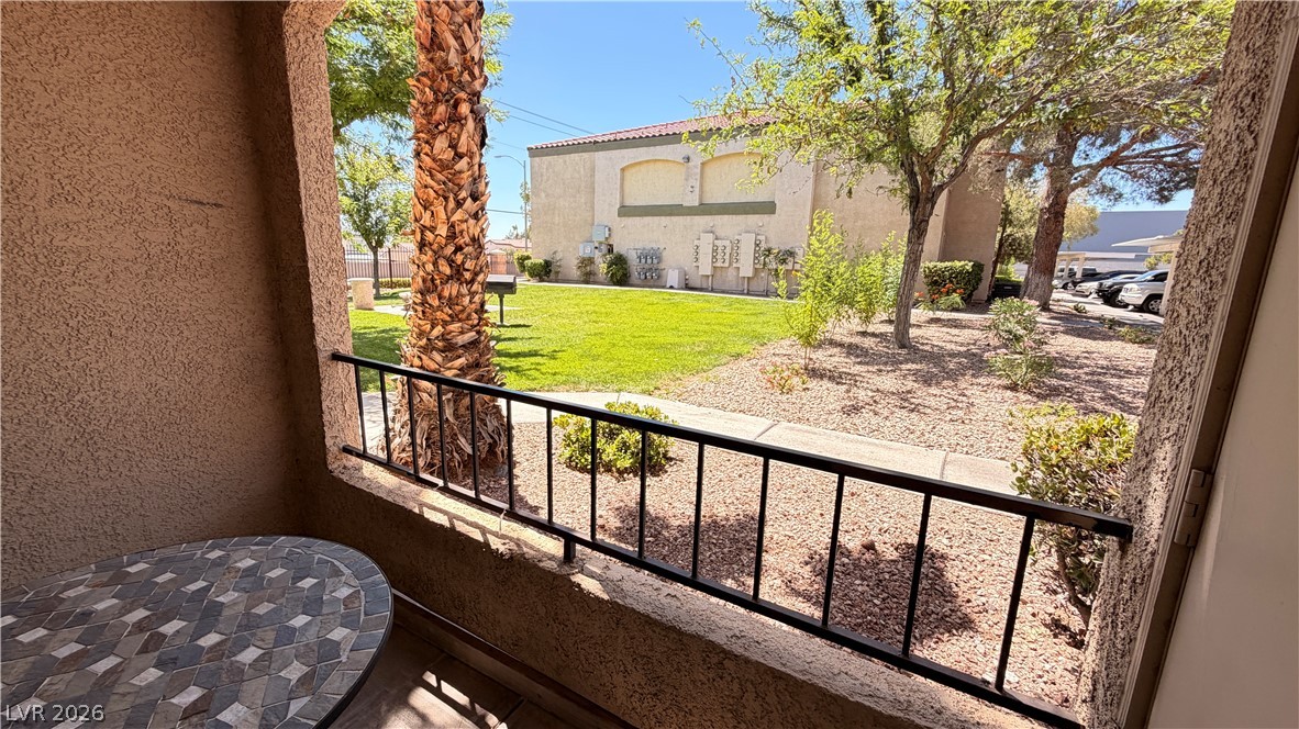 Enjoy the outdoor oasis from this private balcony, overlooking a vibrant green lawn and mature landscaping.