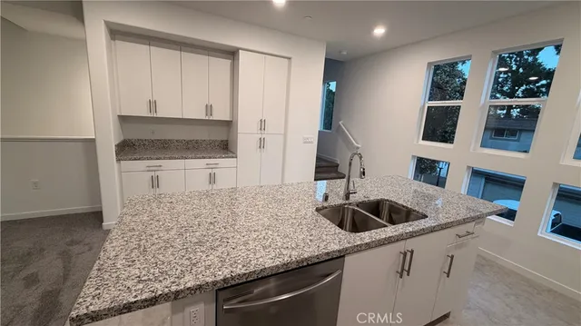 a kitchen with granite countertop a sink and cabinets