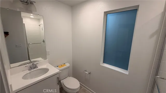 a bathroom with a granite countertop sink toilet and mirror