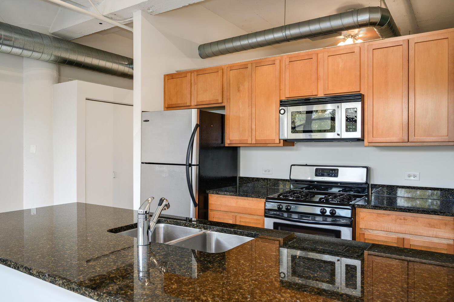 2323 West Pershing Road, Unit 222 Chicago, IL 60609 - Photo 11 of 22 a kitchen with stainless steel appliances granite countertop a sink stove and microwave