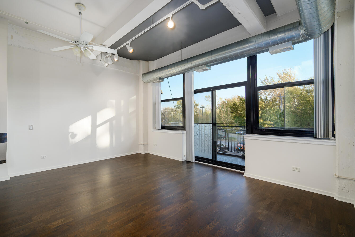 2323 West Pershing Road, Unit 222 Chicago, IL 60609 - Photo 5 of 22 an empty room with wooden floor and windows