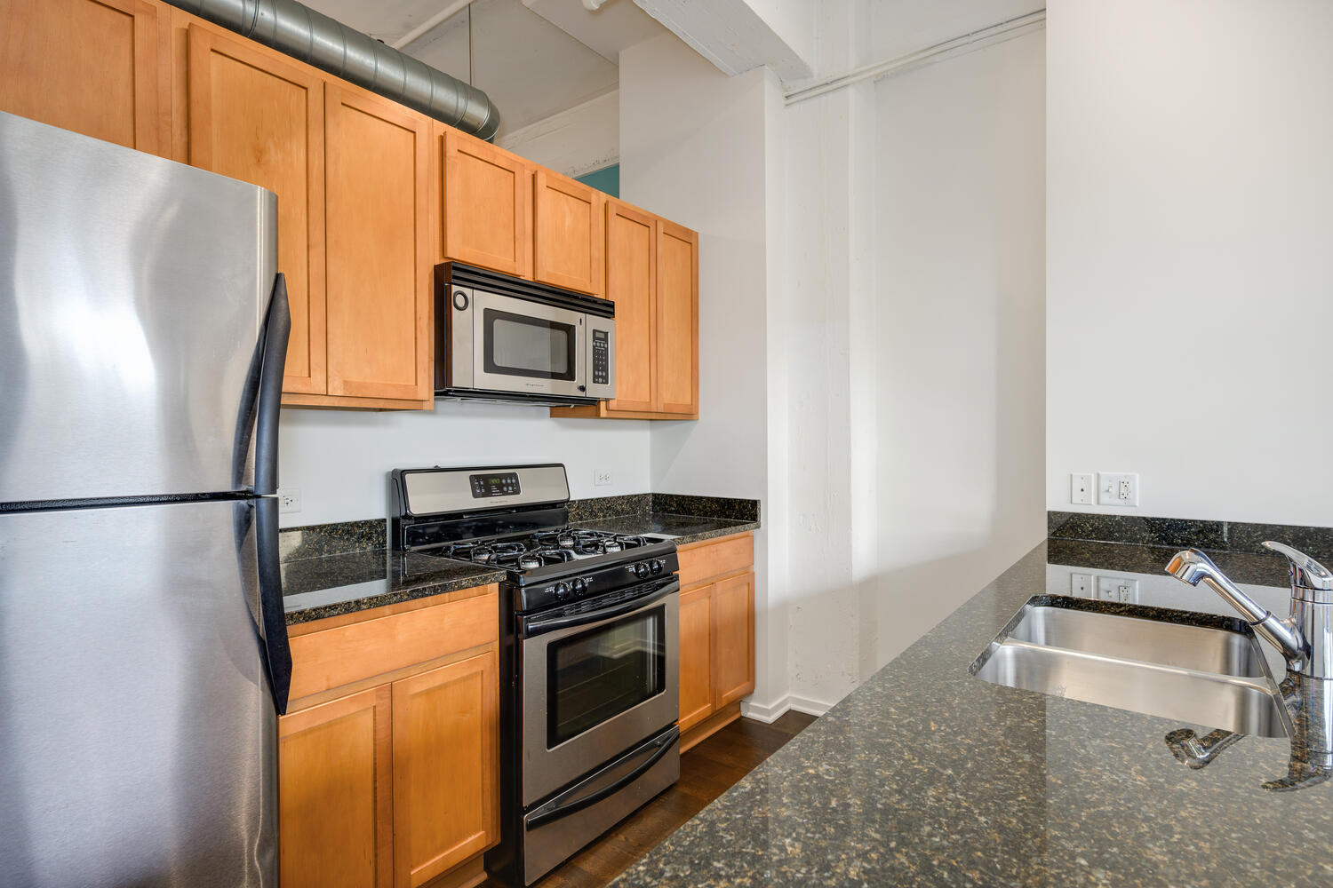 2323 West Pershing Road, Unit 222 Chicago, IL 60609 - Photo 10 of 22 a kitchen with stainless steel appliances granite countertop a refrigerator stove and microwave