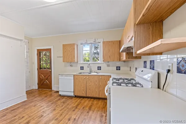 a kitchen with cabinets and wooden floor