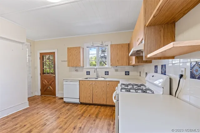 a kitchen with cabinets and wooden floor
