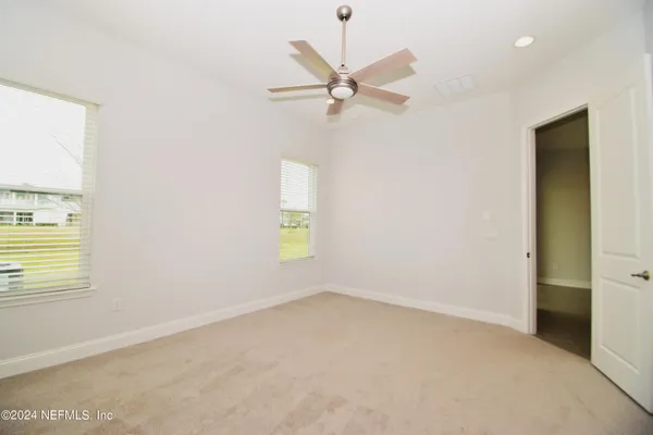 an empty room with a window and a fan