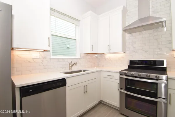 a kitchen with a sink stove and cabinets