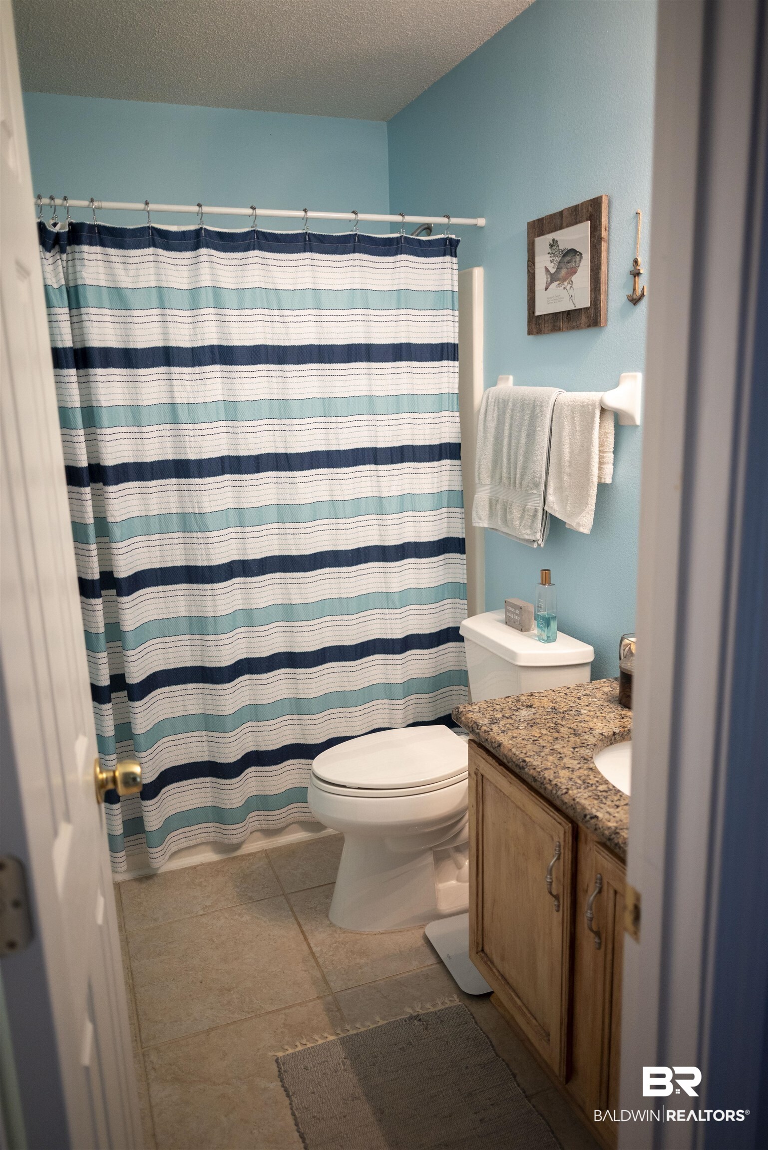 808 Wisteria Lane Foley, AL 36535 - Photo 15 of 19 Bathroom with tile patterned flooring, a textured ceiling, a shower with curtain, vanity, and toilet