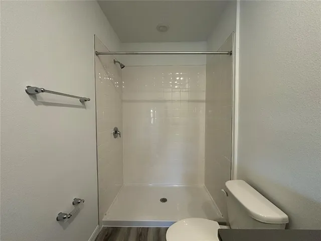 a bathroom with a granite countertop sink toilet a mirror and shower