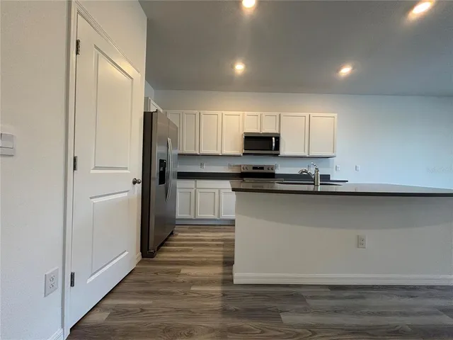 a kitchen with kitchen island a sink a stove and a refrigerator