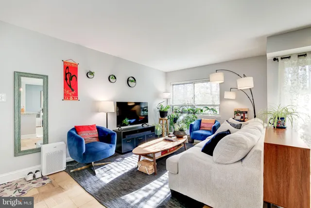 a living room with furniture a flat screen tv and a large window
