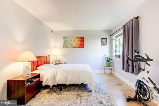 a bedroom with a bed and a dresser next to a window