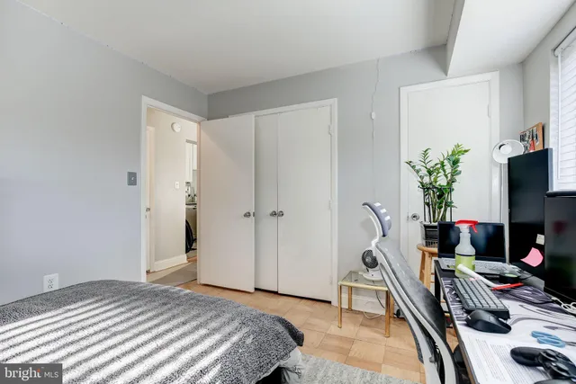 a bedroom with a bed table and a flat screen tv