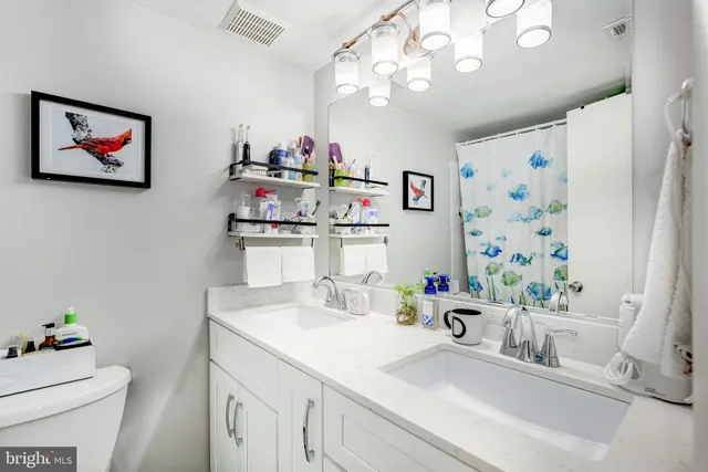 a kitchen with a sink a large mirror and cabinets