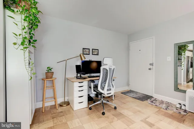 a view of a workspace with furniture and a window