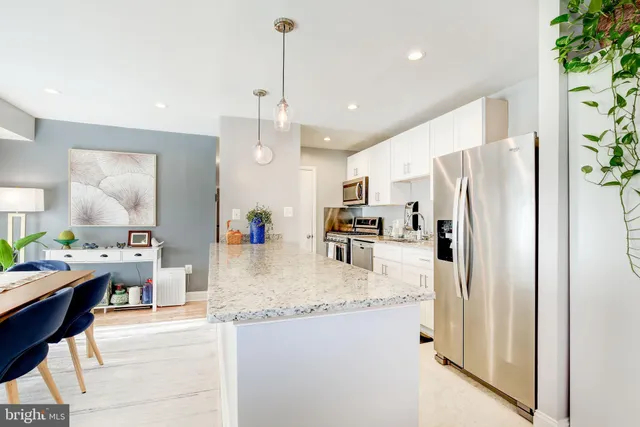 a kitchen with stainless steel appliances granite countertop a refrigerator a sink and a stove