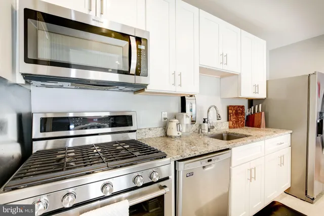 a kitchen with granite countertop a stove and a microwave