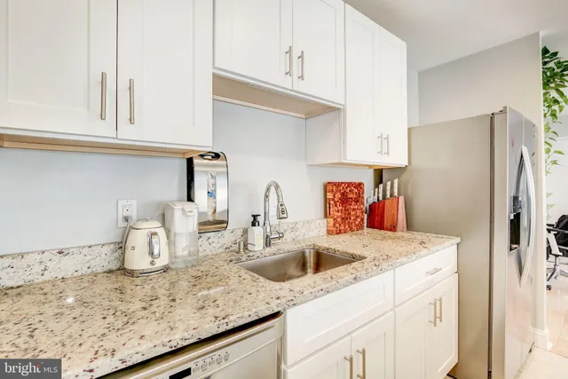 a kitchen with stainless steel appliances granite countertop a sink and refrigerator