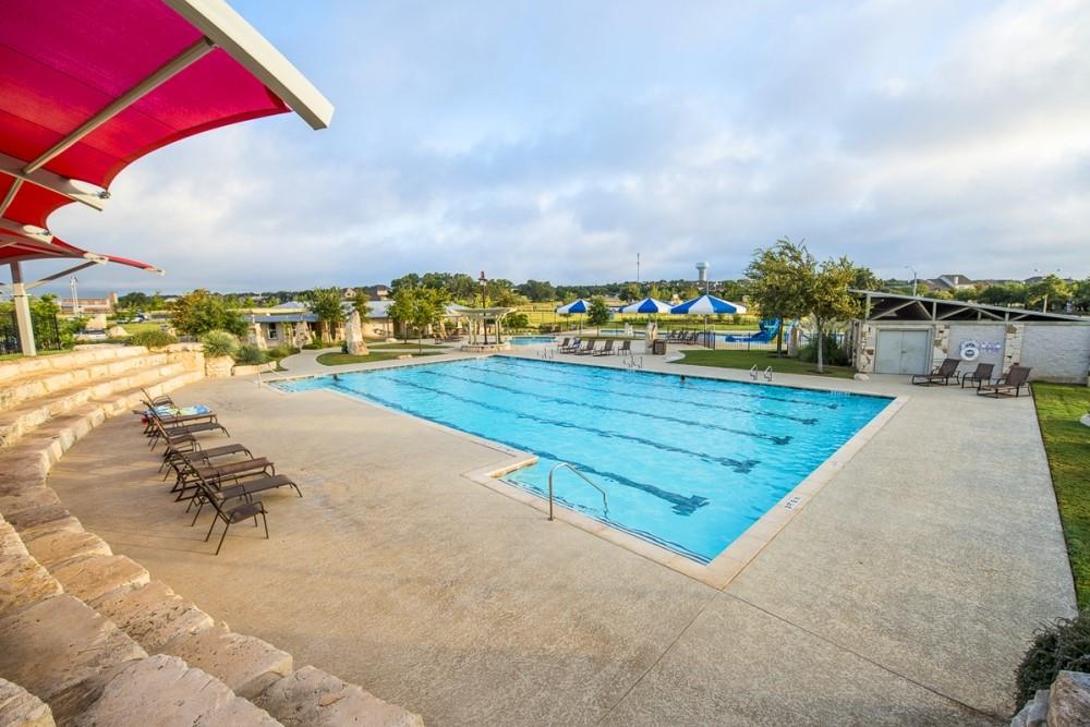 1765 Rowdy Loop, Unit 47 Leander, TX 78641 - Photo 38 of 39 An expansive outdoor swimming pool features lap lanes, a concrete deck, and tiered stone seating.