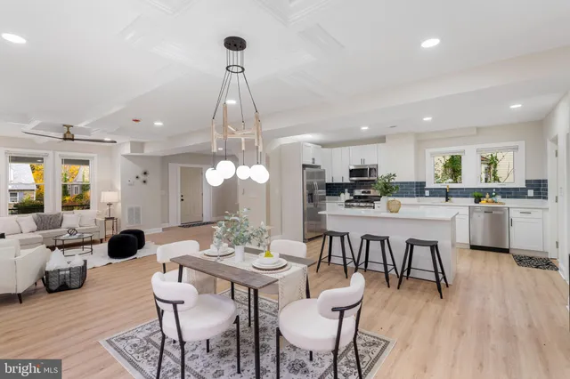a view of a dining room and livingroom with furniture wooden floor a chandelier