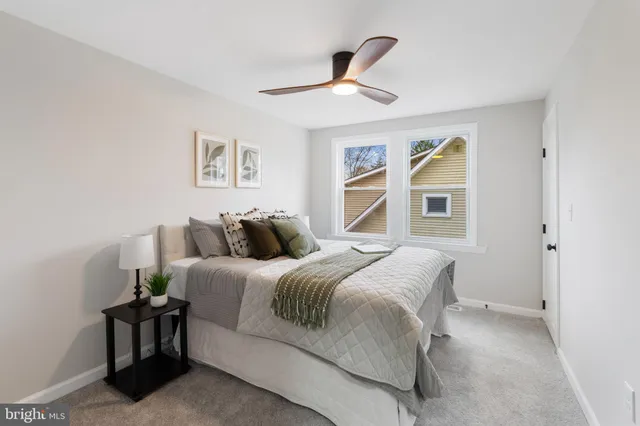 a spacious bedroom with a bed and painting on the wall