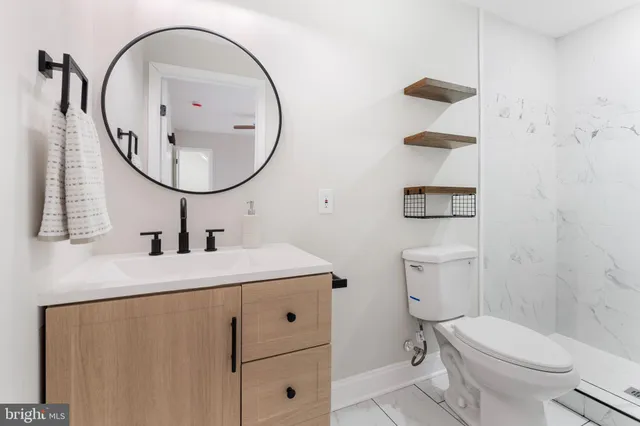 a bathroom with a sink a toilet and a mirror