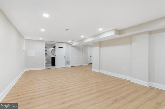 a view of an empty room with wooden floor