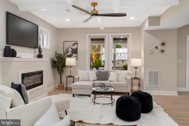 a living room with furniture a flat screen tv and a fireplace