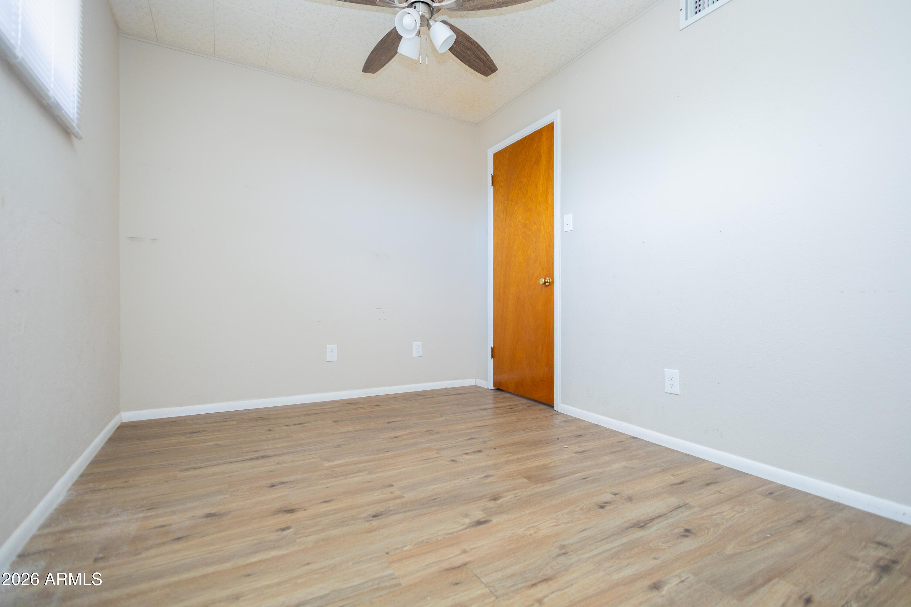 1626 11th Street Douglas, AZ 85607 - Photo 22 of 30 a view of an empty room with wooden floor and a ceiling fan