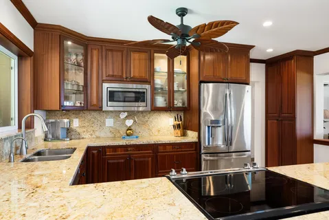 a kitchen with stainless steel appliances granite countertop a refrigerator and a stove top oven