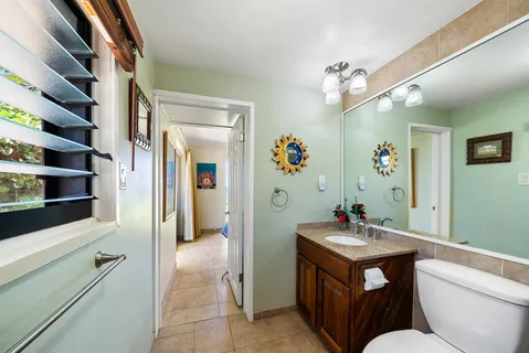 a bathroom with a granite countertop sink toilet and shower