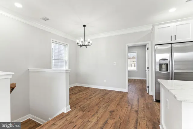 a view of a kitchen with wooden floor and electronic appliances